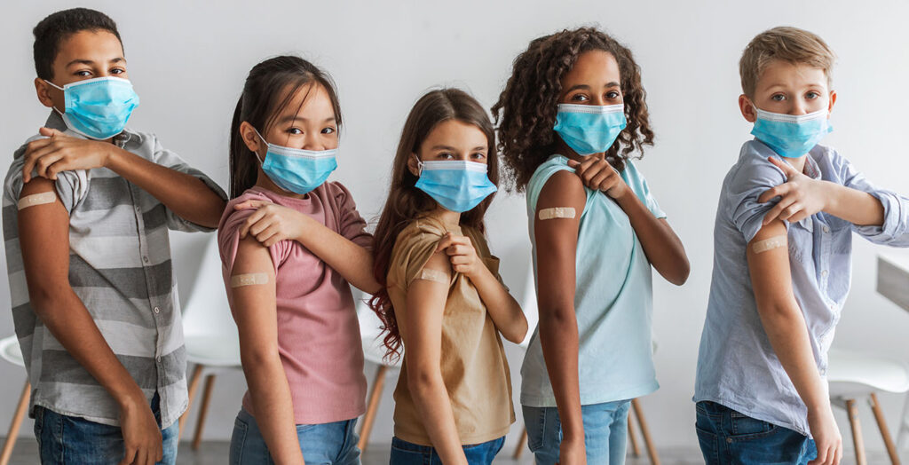 Kids showing their vaccine bandaid